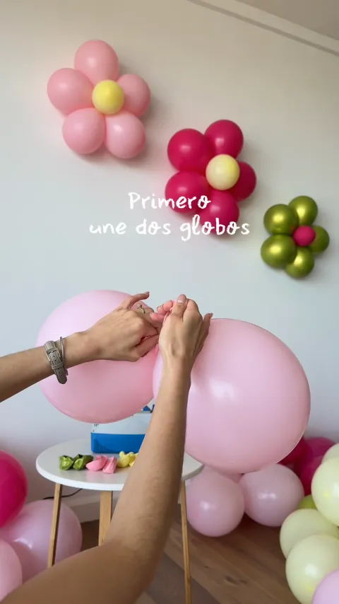 Detalle de las manos uniendo globos para una guirnalda